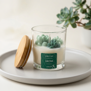 Handgegossene Duftkerze im Glas („Cactus“) mit Sukkulentenmotiv in Grün und Bambusdeckel in moderner, minimalistischer Umgebung