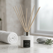 Raumduft-Diffusor mit Rattanstäben („Me Time“) in rundem, weißem Flakon in heller, entspannter Spa-Umgebung