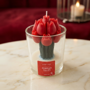 Rote Tulpen-Duftkerze im Glas („Forever Tulips“) in warmer, stimmungsvoller Umgebung mit Kerzenlicht im Hintergrund