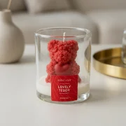 Handgegossene Duftkerze im Glas („Lovely Teddy“) mit Bärenfigur und Herz in minimalistischer, moderner Inszenierung