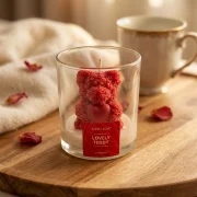 Handgegossene Duftkerze im Glas („Lovely Teddy“) mit Bärenfigur und Herz in gemütlicher Inszenierung