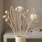 Dekorative Rattanstäbe für Duftdiffusor mit floralen und geflochtenen Elementen in natürlicher, warmer Umgebung
