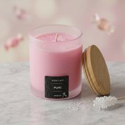 Detailaufnahme einer rosa Duftkerze im Glas („Pure“) mit Bambusdeckel und dekorativen Zuckerelementen