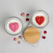 Draufsicht von zwei Duftkerzen im Glas („Sweet Heart“) mit geometrischem Herzmotiv in Rot und rosa mit Bambusdeckel